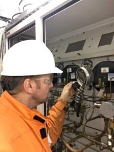 working dive technician inspecting pressure gauge